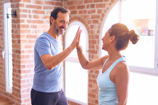 middle-aged-couple-high-fiving-after-workout
